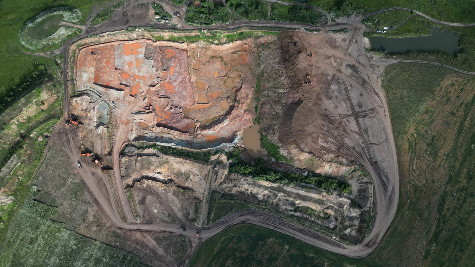Aerial view of a quarry with layered rock faces and working routes